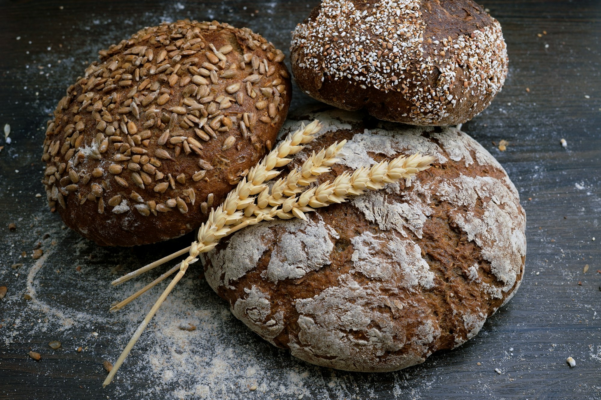 Fresh loaves of sourdough bread stacked on a wooden bakery counter